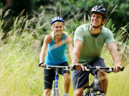 Cyklostezka okolo jezera Neusiedler See Pár na kole projíždí krajinou s rákosím
