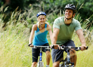 Cyklostezka okolo jezera Neusiedler See Pár na kole projíždí krajinou s rákosím