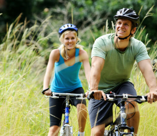 Cyklostezka okolo jezera Neusiedler See Pár na kole projíždí krajinou s rákosím