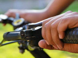 Detail rukou na řidítkách kola
