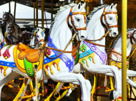 Kolotoč Lignano Sabbiadoro Carrousel Vyřezávaní koně na starožitném kolotoči Lignano Sabbiadoro Carrousel v Lignanu