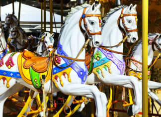 Kolotoč Lignano Sabbiadoro Carrousel Vyřezávaní koně na starožitném kolotoči Lignano Sabbiadoro Carrousel v Lignanu