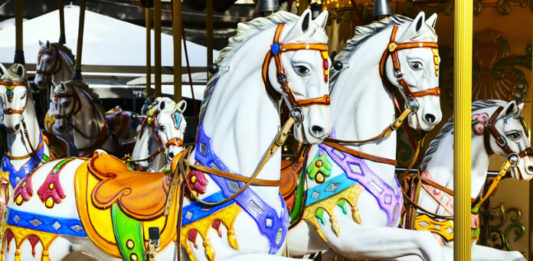 Kolotoč Lignano Sabbiadoro Carrousel Vyřezávaní koně na starožitném kolotoči Lignano Sabbiadoro Carrousel v Lignanu
