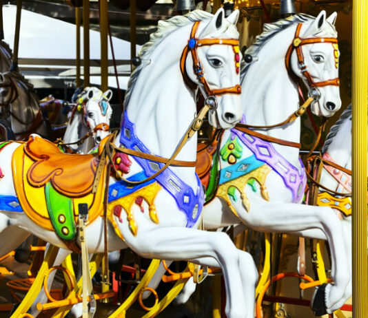 Kolotoč Lignano Sabbiadoro Carrousel Vyřezávaní koně na starožitném kolotoči Lignano Sabbiadoro Carrousel v Lignanu